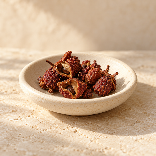 a few dried reddish-brown timur pepper husks in an ivory dish