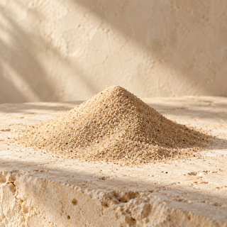 a small mound of fine pale sand on ivory limestone