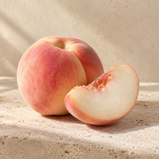 a blush-skinned white peach cut to reveal pale white flesh